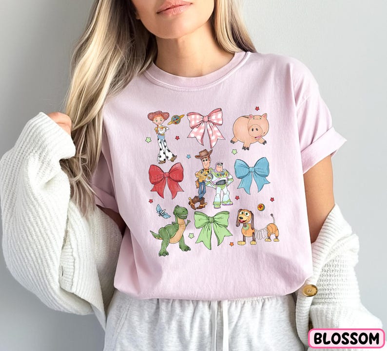 a woman wearing a pink shirt with cartoon characters on it