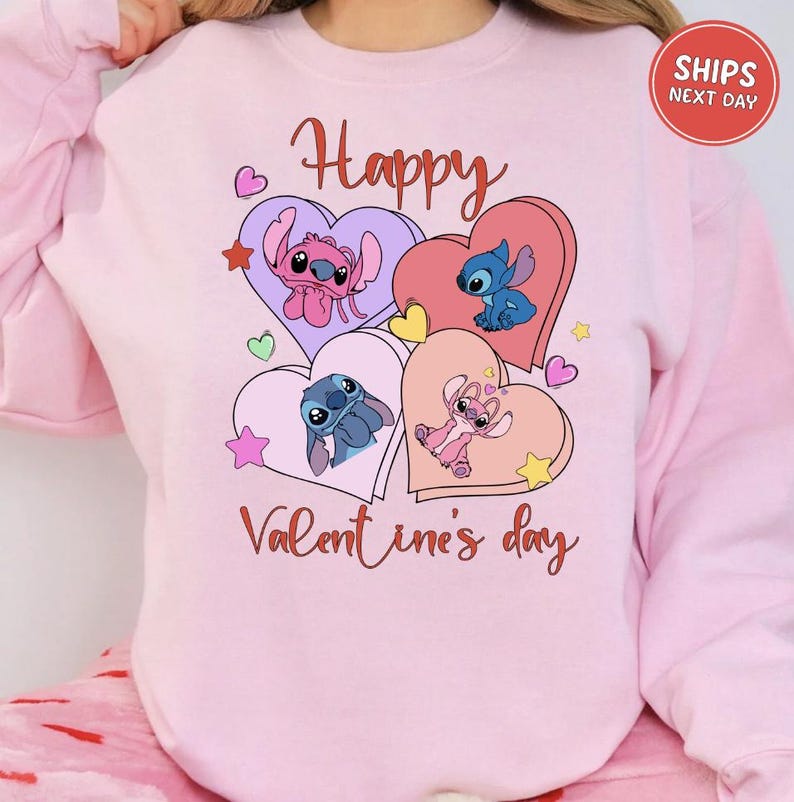 A pink sweatshirt with a graphic design featuring characters from the Disney animated film "Stitch". The design includes hearts, stars, and the text "Happy Valentine's day".