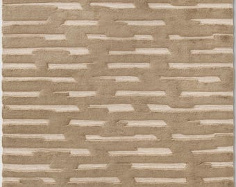May include: A rectangular rug with a textured, geometric pattern in shades of beige and cream. The design features horizontal, rectangular shapes. The rug has tassels along the top and bottom edges, adding a decorative element. This rug is suitable for living rooms and bedrooms.