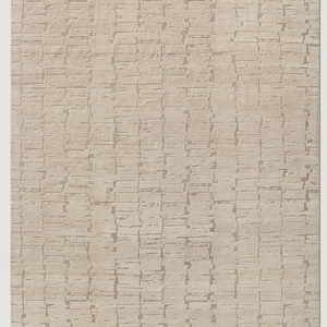 May include: A rectangular beige rug with a textured, brick-like pattern. The design features a repeating series of rectangular shapes in varying shades of beige, creating a subtle, yet visually interesting surface. This rug is suitable for living rooms and bedrooms.