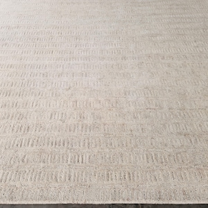 Op de afbeelding: Een groot, rechthoekig tapijt met een neutraal kleurenpalet. Het tapijt heeft een getextureerd, gestreept patroon dat horizontaal over het oppervlak loopt. De kleur is lichtbeige, wat een zachte en uitnodigende uitstraling creëert. Geschikt voor woon- en slaapkamers. Afmetingen: 200 cm x 300 cm.