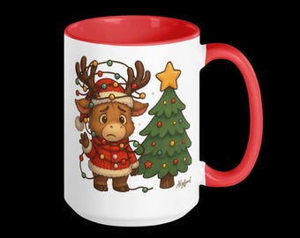 Könnte beinhalten: Weißer Keramikbecher mit roter Innenseite und Henkel. Der Becher zeigt eine Cartoon-Illustration eines Rentiers mit Weihnachtsmütze und rotem Pullover, verheddert in Lichterketten, neben einem geschmückten Weihnachtsbaum.