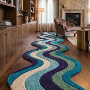 May include: A multi-coloured, wavy rug in shades of teal, blue, purple, and beige. The rug is placed on a dark wood floor, adding a vibrant accent to the room. The rug's design resembles a flowing river.