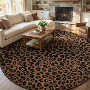 May include: A round area rug with a leopard print pattern in shades of brown and black. The rug is placed in a living room setting, with a sofa, coffee table, and fireplace visible in the background. The rug's diameter is approximately 8 feet.