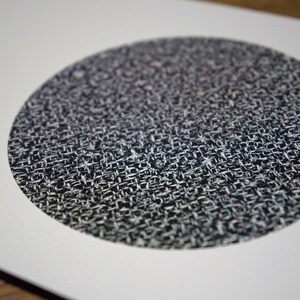 May include: A close-up of a circular design with a woven texture. The pattern is primarily black and white, creating a high-contrast visual effect. The design is centered on a white background.