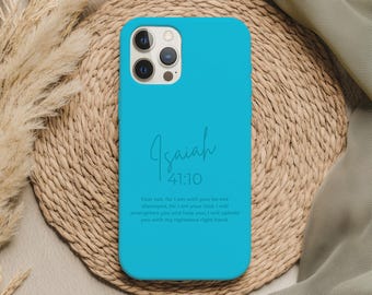 Può includere: Una custodia per telefono turchese brillante con il testo "Isaia 41:10" in un carattere scritto a mano. La custodia presenta un versetto biblico sotto. La custodia del telefono è appoggiata su un tappetino intrecciato.