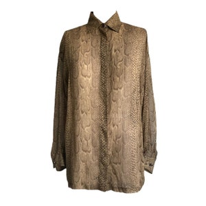 May include: A long-sleeved button-down shirt with a snakeskin print in shades of brown and beige.