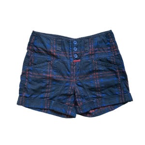 Puede incluir: Shorts de pana azul y rojo a cuadros con cintura alta y cierre de botón. Los pantalones cortos tienen un dobladillo con vuelta y están hechos de tela de pana.