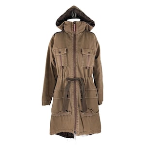 May include: A brown hooded parka with a drawstring waist and multiple pockets. The jacket has a zip closure and a brown fur-lined hood.