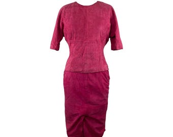 May include: A pink suede dress with a fitted bodice and a skirt that falls to the knee.