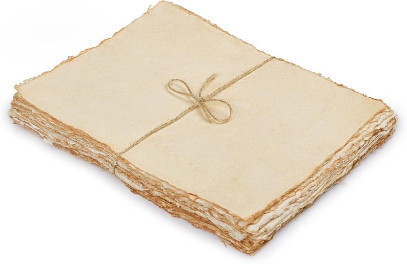 May include: A stack of handmade paper with deckled edges, tied with twine. The paper has a warm, off-white color and a textured surface. The twine is tied in a simple bow. The paper appears to be suitable for writing or art projects.