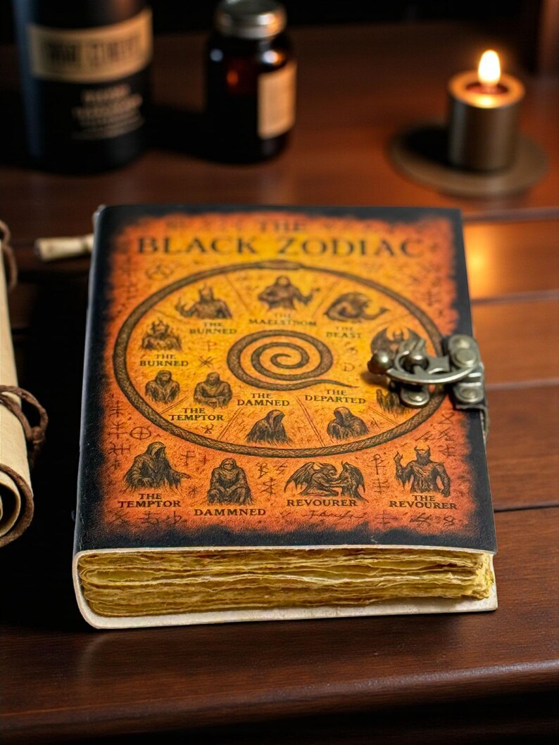 May include: A leather-bound journal titled "The Black Zodiac" with an aged, antique appearance. The cover displays zodiac illustrations and is fastened with a metal clasp. The pages are yellowed, giving the impression of an old, possibly magical, book.