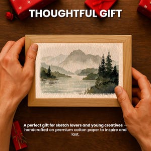 May include: A framed watercolor landscape painting with a natural wood frame. The artwork depicts a serene scene of mountains, a lake, and trees in shades of green and gray. Text reads "THOUGHTFUL GIFT".