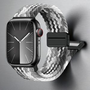 May include: A black smartwatch with a grayscale braided band. The watch face is black with white hands and markers. The band is a mix of white, gray, and black. The watch is attached to a black clasp.