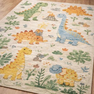 Op de afbeelding: Handgeknoopt dinosaurus vloerkleed met een crèmekleurige achtergrond en kleurrijke dinosaurus illustraties. Het vloerkleed toont groene, gele, oranje en blauwe dinosaurussen, omringd door planten en een vulkaan. Tekst: Handgeknoopt Dinosaurus Vloerkleed.
