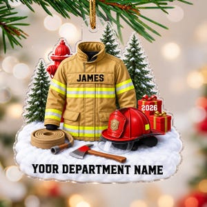 May include: A clear acrylic Christmas ornament featuring a tan firefighter jacket with the name JAMES, a red helmet, a coiled hose, a fire hydrant, an axe, and two red gift boxes labeled 2026. The base has the text YOUR DEPARTMENT NAME.