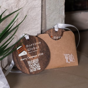 May include: Wooden Christmas ornament with the text "Horizon Global Real Estate" and "Merry Christmas 2026". The ornament is round with a QR code. A brown paper gift tag with the words "With Love" is also visible.
