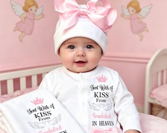 May include: A white baby onesie and matching beanie set featuring a large pink satin bow on the hat and a smaller pink bow on the onesie. The text reads Sent With A KISS From Grandad IN HEAVEN with a pink crown and grey angel wings graphic.