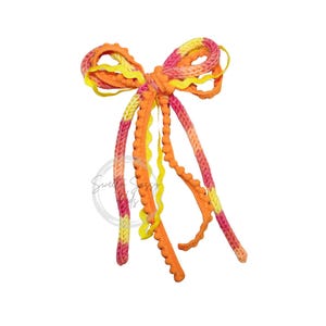 May include: A decorative bow crafted from multiple strands of textured ribbon and yarn in vibrant shades of orange, pink, and yellow. The design features a mix of solid orange rickrack trim, variegated yarn, and pom-pom fringe, tied together.