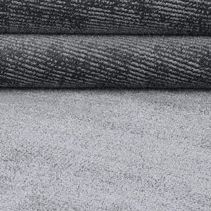 May include: Close-up of a gray carpet with a textured surface. The carpet is rolled up in two layers, revealing the woven pattern. The bottom layer is a flat, light gray surface.