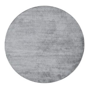 May include: A round, light gray rug with a textured surface. The rug has a solid color and a simple design, suitable for various interior styles. The rug is a neutral color that can complement different decor.