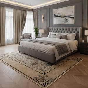 May include: A luxurious bedroom featuring a large bed with a tufted headboard, layered bedding, and decorative pillows. The room has gray walls, a patterned rug, and neutral-toned curtains. A painting hangs above the bed, and a small chair sits near the window.