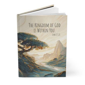 May include: A hardcover book with a cream-colored cover featuring an artistic landscape illustration of a tree and mountains. The text "The Kingdom of God is within you. Luke 17:21" is printed in black on the upper portion of the front cover.