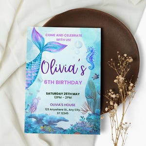 Può includere: Un invito di compleanno a tema sirena con un design ad acquerello. L'invito presenta una coda di sirena, un cavalluccio marino ed elementi sottomarini. Il testo include "Olivia's 6th Birthday" e i dettagli dell'evento.