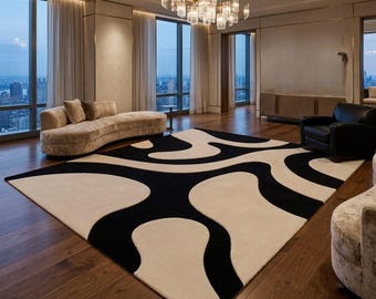 May include: A large rectangular area rug featuring a bold, high-contrast pattern of flowing, organic black shapes set against a solid cream-colored background. The rug covers a significant portion of the dark hardwood floor in the room.