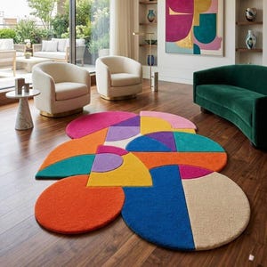 Könnte beinhalten: Ein Teppich mit einem mehrfarbigen geometrischen Muster, das aus verschiedenen kreisförmigen und halbkreisförmigen Formen besteht. Der Teppich zeigt lebendige Blöcke in Orange, Blau, Gelb, Pink, Lila und Creme in einer geschichteten Anordnung.