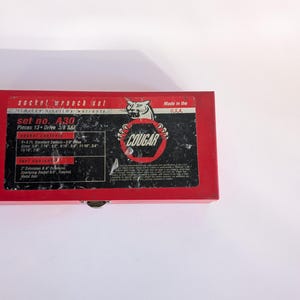 May include: A red socket wrench set in a metal box. The box has a black label with white text that reads "socket wrench set" and "set no. A30". The label also features the word "COUGAR" and "Made in the U.S.A."