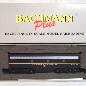 May include: A black model train car with gold and silver accents, labeled "PENNSYLVANIA" and "96408." The box reads "BACHMANN Plus" and "EXCELLENCE IN SCALE MODEL RAILROADING."
