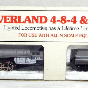 May include: A model train set in a box. The box is white with red text that reads "OVERLAND 4-8-4 & TENDER". The set includes a silver and black locomotive and a black tender. The locomotive has the number "885" on the side.