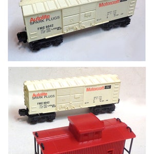 Può includere: Un set di tre vagoni di treno giocattolo. Un vagone è rosso e dice "A.T. & S.F. 9071". Un altro vagone è bianco e dice "Motorcraft Ford" e "Autolite Spark Plugs FMC 9042". Il terzo vagone è bianco e dice "Motorcraft Ford".