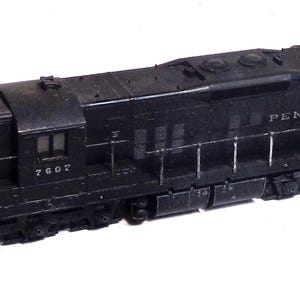 May include: Black model train locomotive with the words "PENNSYLVANIA" on the side and the number "7607" on the front.