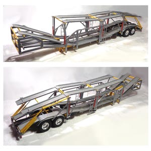 May include: A two-part image shows a model car hauler. The hauler is primarily gray with yellow and red accents. It has multiple levels for transporting vehicles and features ramps for loading and unloading. The hauler has a set of wheels at the rear.