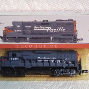 May include: A model train locomotive in a box. The dark blue train has the words "Southern Pacific" printed on the side. The box has the word "LOCOMOTIVE" printed on it, and a warning about small parts. The train is 6 inches long.