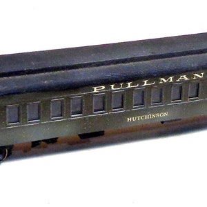 以下が含まれることがあります： 側面に「PULLMAN」と「MUTCHINSON」の文字が印刷された濃い緑色の模型の列車車両。車両には複数の窓と黒い屋根があります。