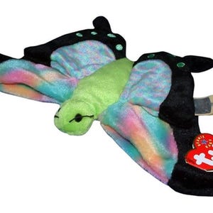 May include: A soft toy butterfly with black wings and a body of green and rainbow hues. The wings have a tie-dye effect with blue, pink, and yellow shades. A red heart-shaped tag is attached to the wing.