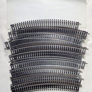 HO Scale Lot of TWENTY-FIVE(25) Pieces of 18 inch radius Curve Nickel-Silver Train Track!! Pre-owned with sand paper to clean pieces.
