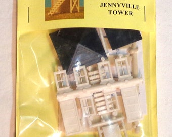 May include: A plastic model kit for a HO scale Jennyville Tower. The kit includes a tower, windows, and a roof. The packaging is yellow with a red and white logo for AM Models.