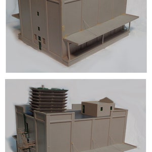 May include: A model of a large, grey building with a brown roof and a metal fire escape. The building has a loading dock with a canopy and a series of windows.