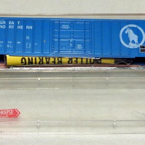May include: A blue model train boxcar with the words "GREAT NORTHERN" and a white logo of a horse inside a circle. The boxcar is in a clear plastic case with the word "ROUNDHOUSE" on the case.