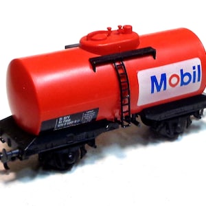 May include: Red toy train car with a black tank labeled "Mobil" and a ladder on the side.
