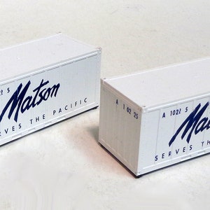 May include: Two white shipping containers with the text "Matson Serves The Pacific" and the number "A 1021 5" and "A 1022 5" printed on them.