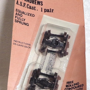 May include: Package of Kadee HO scale 509 Andrews A.S.F. Cast freight trucks. The package is pink and white with black text. The package includes two non-magnetic freight trucks with free rolling contoured axles.