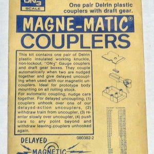 May include: A vintage package for Kadee Magne-Matic Couplers, model 803, for ON3 scale model trains. The package is tan with blue and white text, and features diagrams and text describing the couplers' function and use.