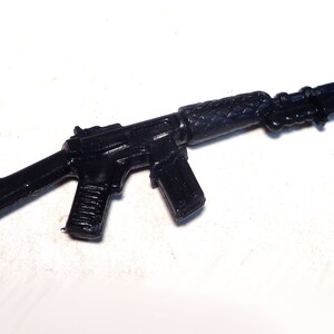 May include: A black plastic toy rifle with a bayonet attached to the barrel.