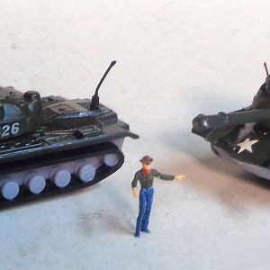 Puede incluir: Dos tanques militares de juguete, ambos verdes con detalles negros, están sobre una superficie blanca. Cada tanque tiene el número "8126" impreso en el lateral. Un tanque tiene una estrella blanca en el lateral.