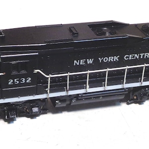 May include: Black model train locomotive with white lettering that reads "NEW YORK CENTRAL" and "2532".
